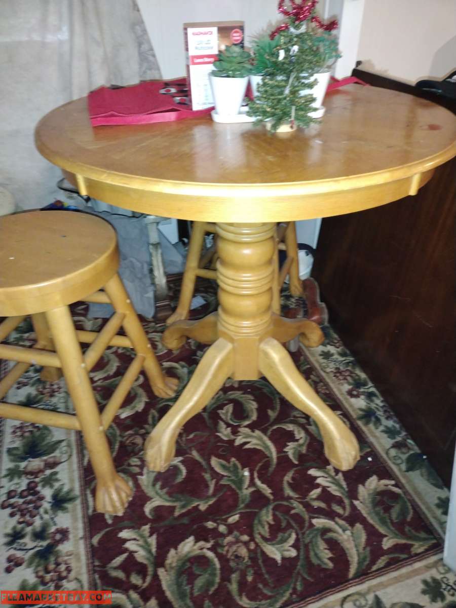 a light wooden high top table with two wooden stools