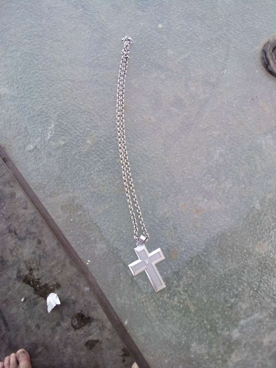 sterling silver necklace with a cross and a diamond in the m