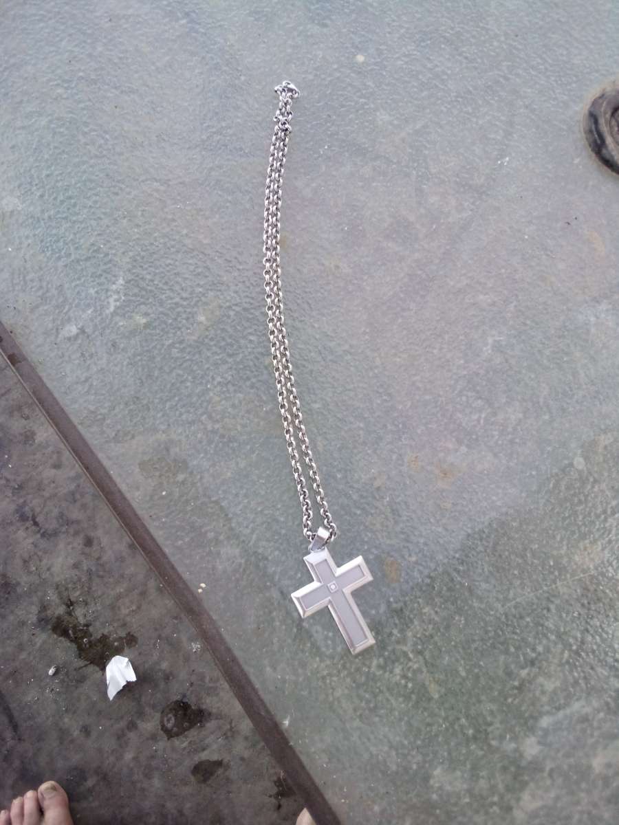 sterling silver necklace with a cross and a diamond in the m