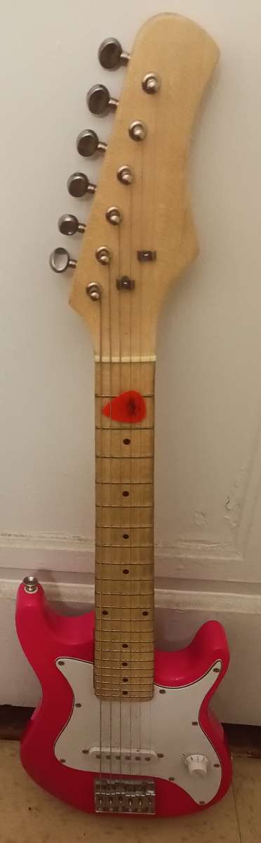 pink electric guitar with pick