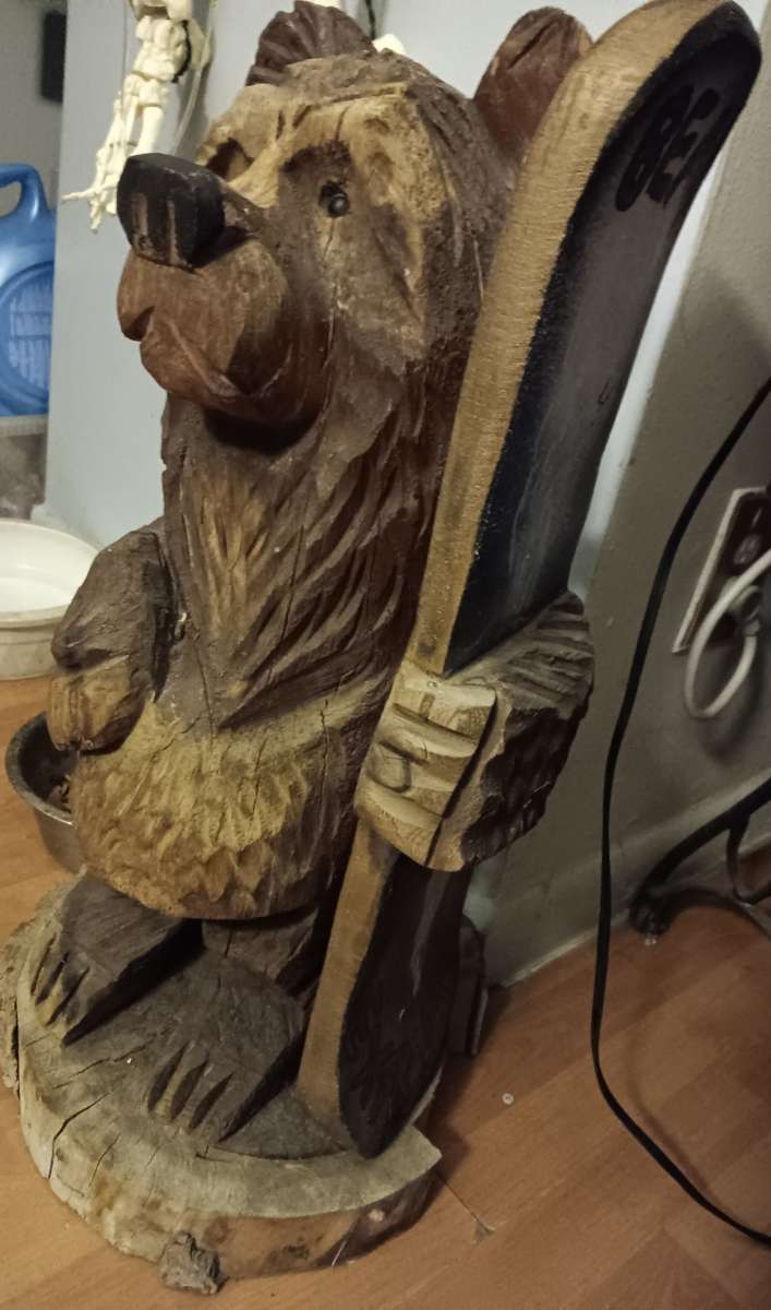 Bear holding surfboard that says BEAR EXTREME