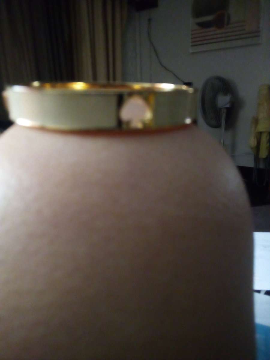 a black bracelet and a white Kate Spade bracelet