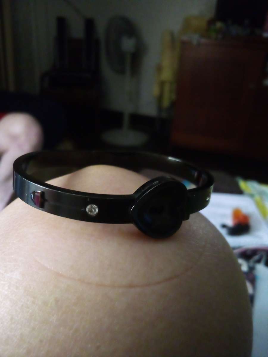 a black bracelet and a white Kate Spade bracelet