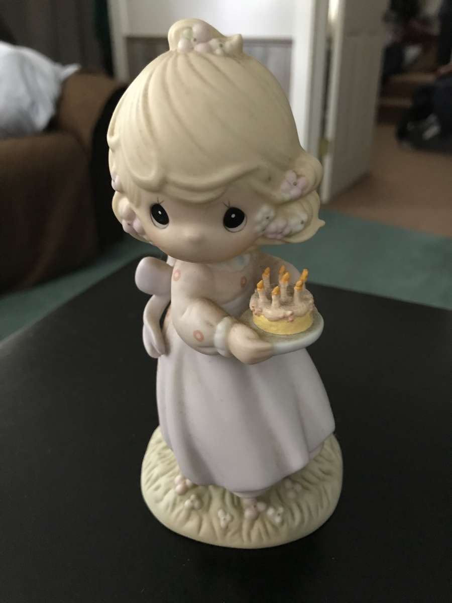 precious moment girl holding a cake