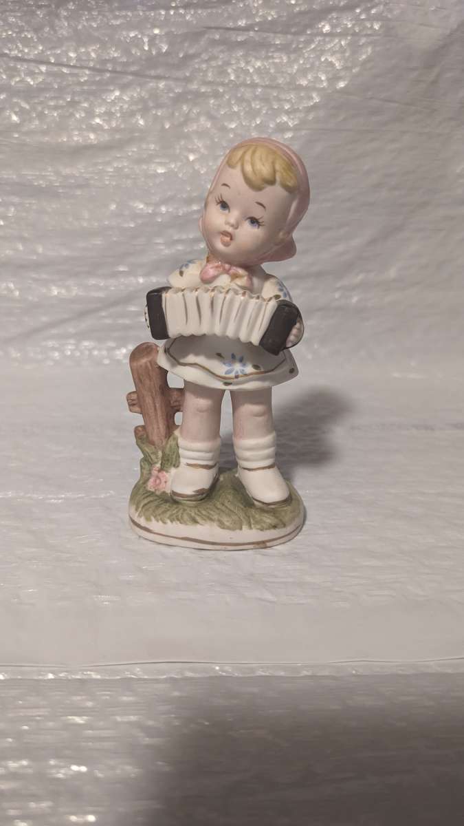 A Little Girl Playing an Accordion with a White Dress