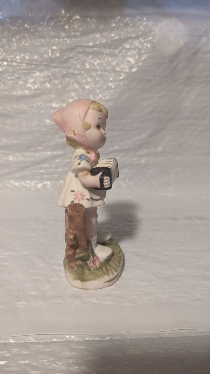 A Little Girl Playing an Accordion with a White Dress