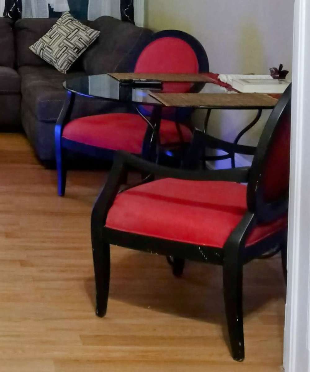 glass table with 2 red black vintage chairs