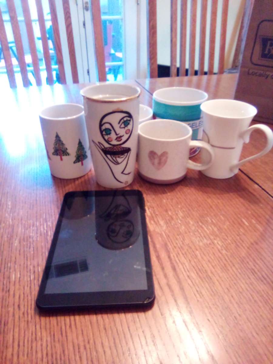 black tablet and Starbucks coffee mugs