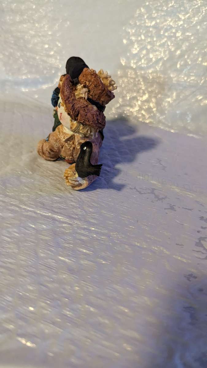 Resin Scarecrow Laying Down With Legs Bent Holding A Crow