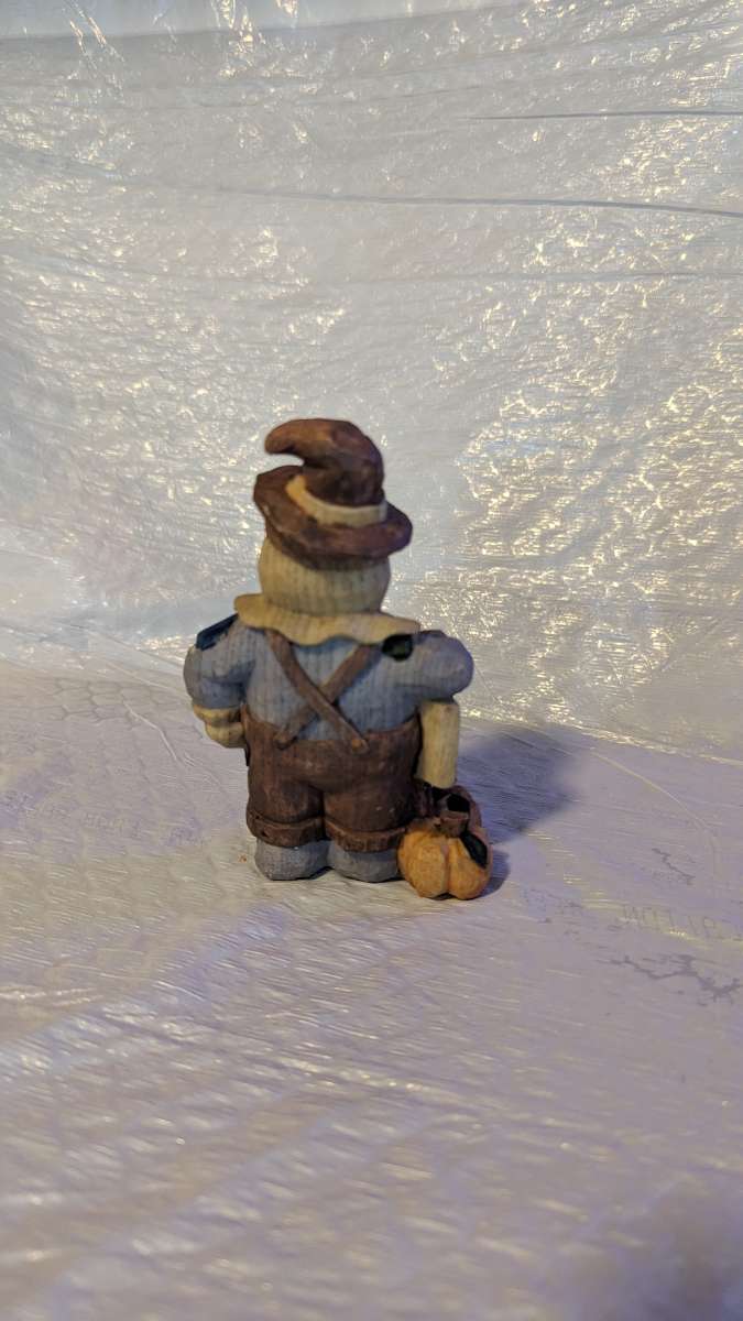 Happy Wood Scarecrow has a couple of Pumpkins and a little S