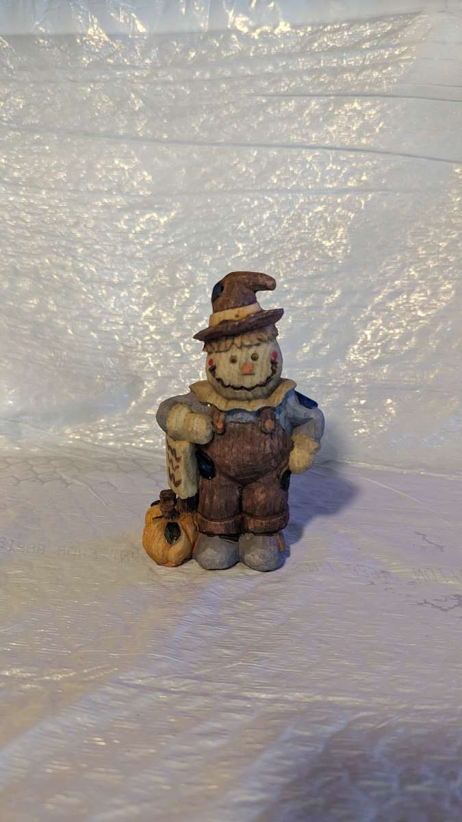Happy Wood Scarecrow has a couple of Pumpkins and a little S