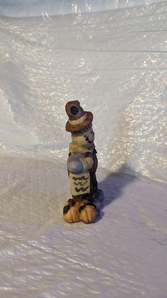 Happy Wood Scarecrow has a couple of Pumpkins and a little S