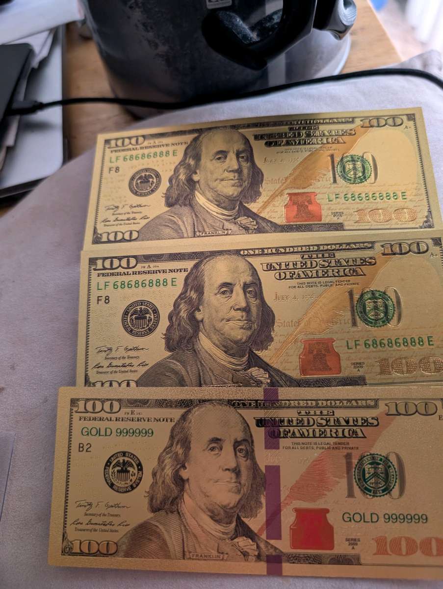 Three gold 100 bills