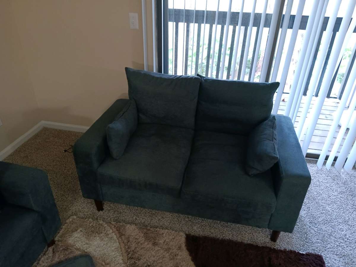 couch and loveseat and cabinet with glass shelves very clean