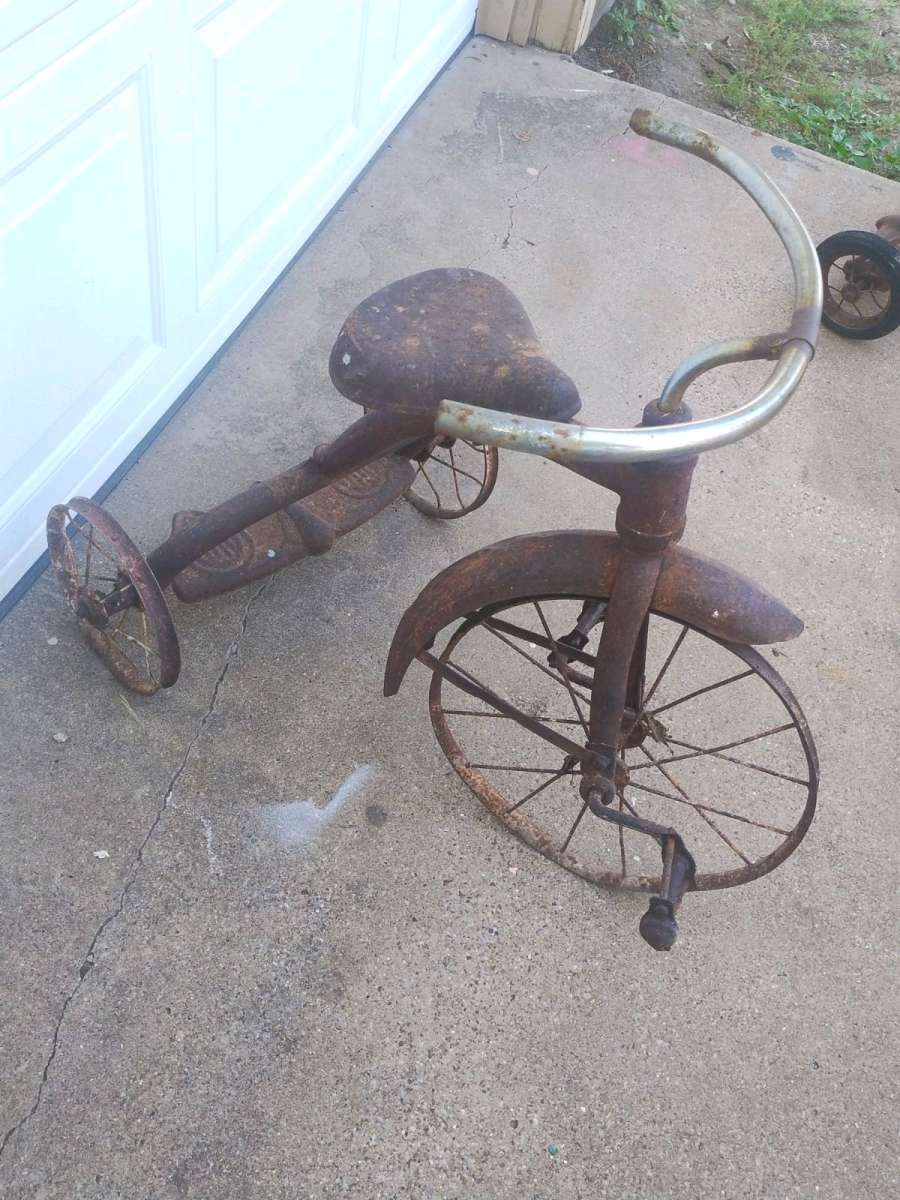 antique tricycle and a antique grape soda cooler