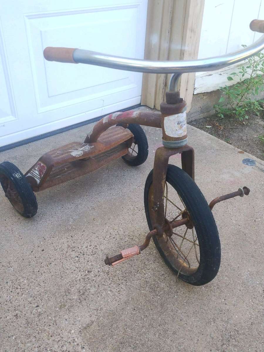 antique tricycle and a antique grape soda cooler