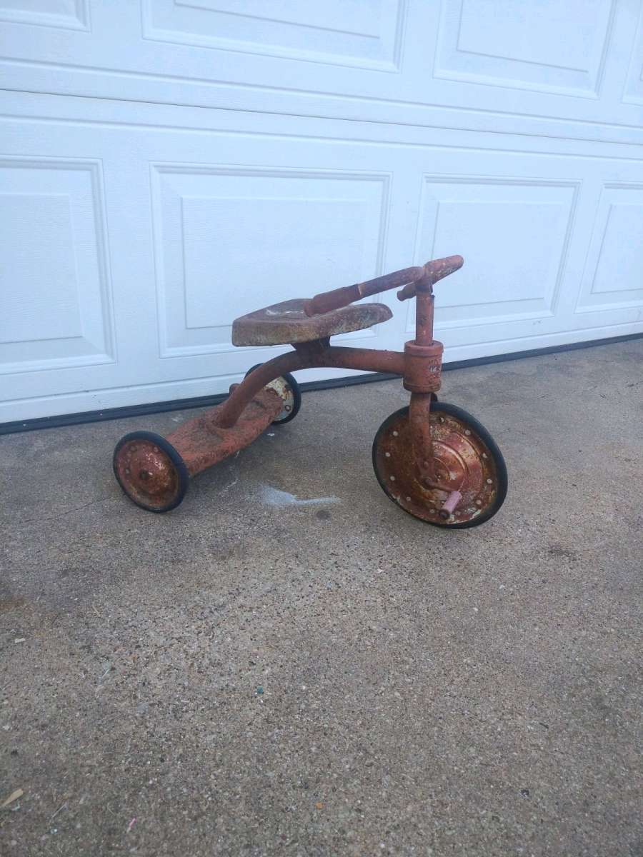 antique tricycle and a antique grape soda cooler