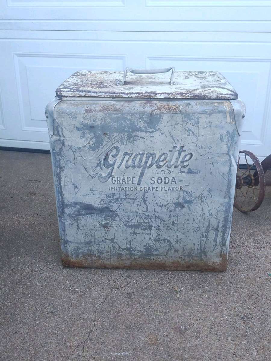 antique tricycle and a antique grape soda cooler