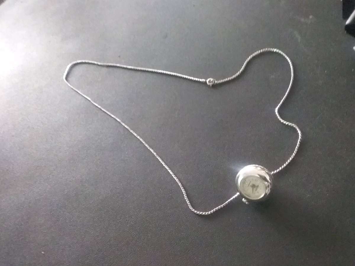 silver necklace with timepiece