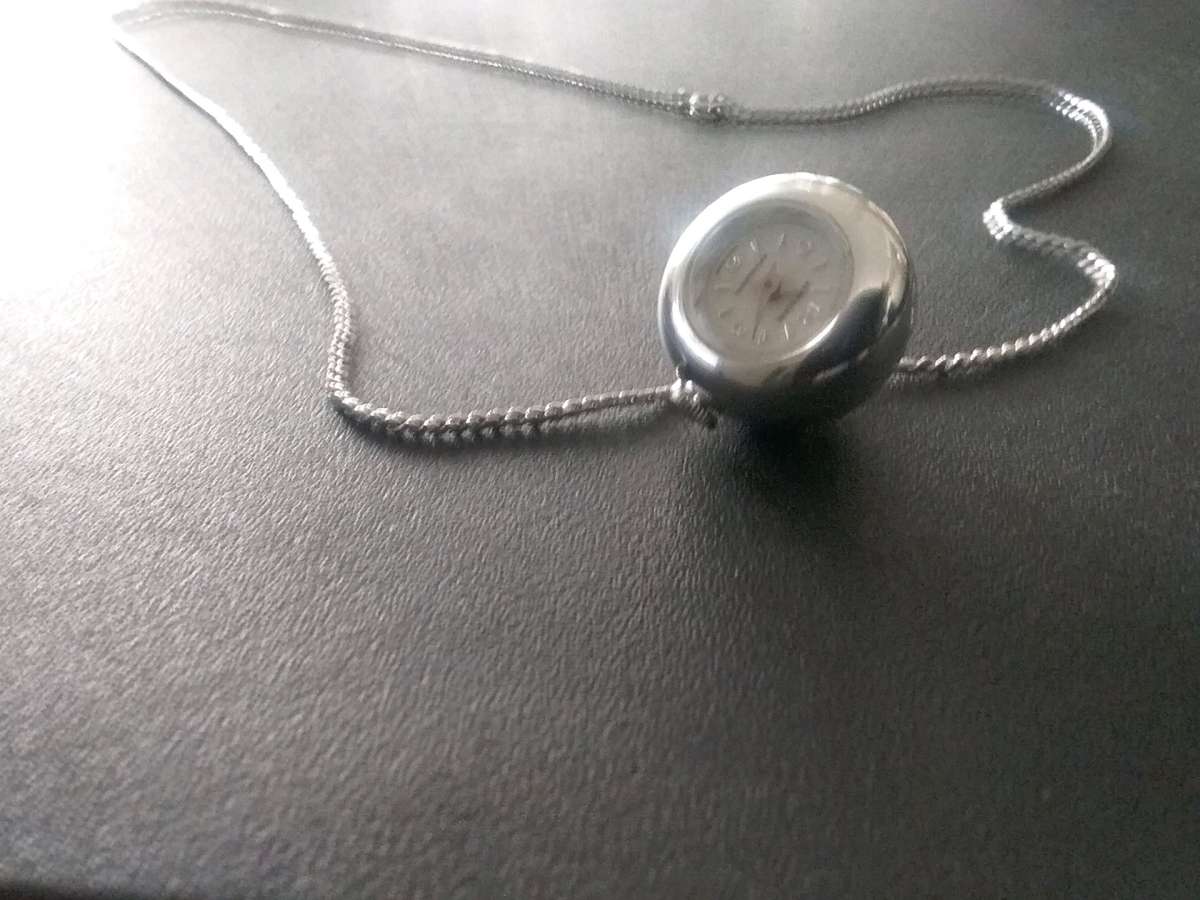 silver necklace with timepiece