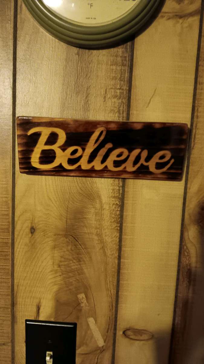 torched Believe sign