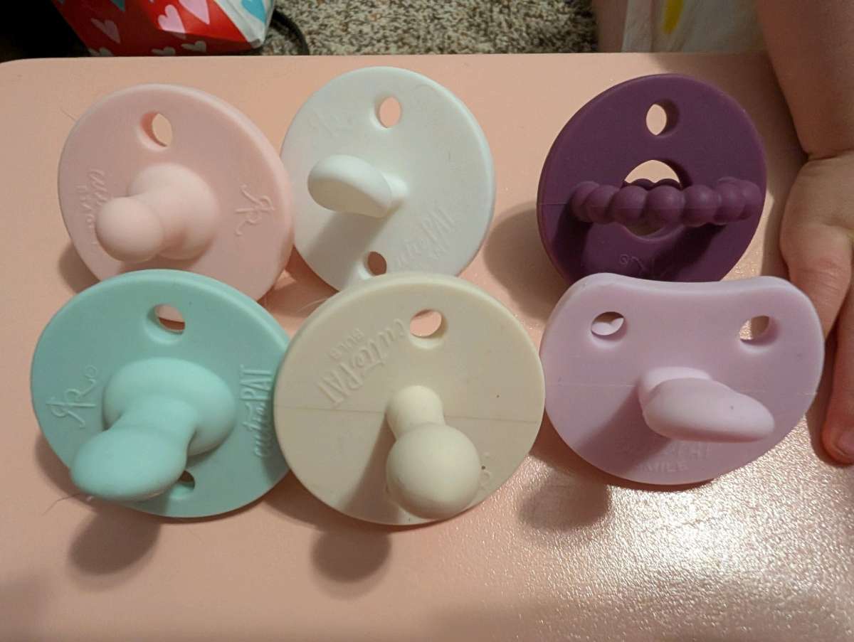 5 Cutie Pat Pacifiers and a teether