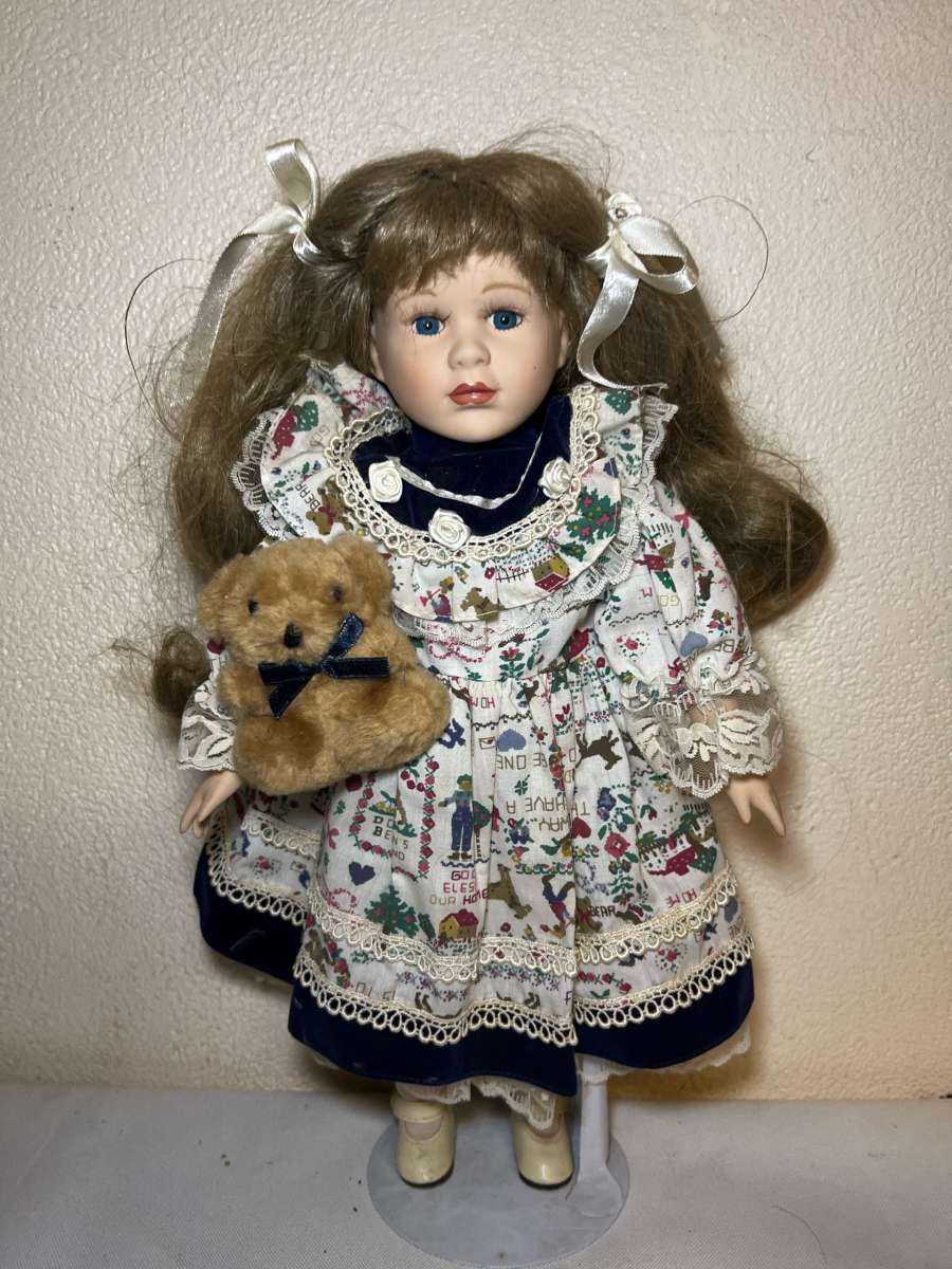 vintage porcelain doll hoding stuffed bear