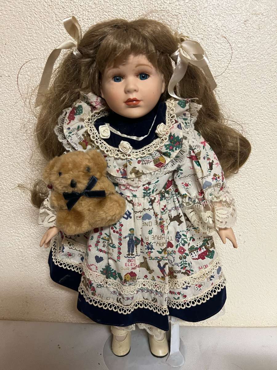 vintage porcelain doll hoding stuffed bear