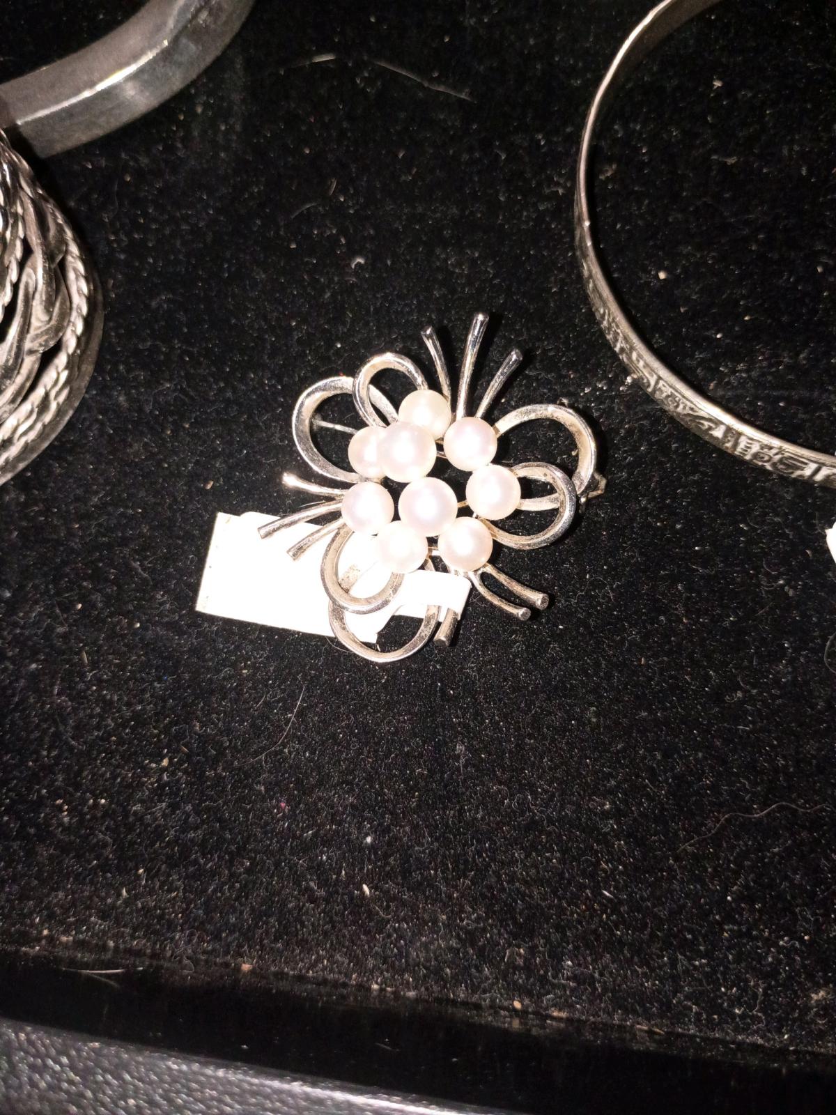 a silver pendant with pearls