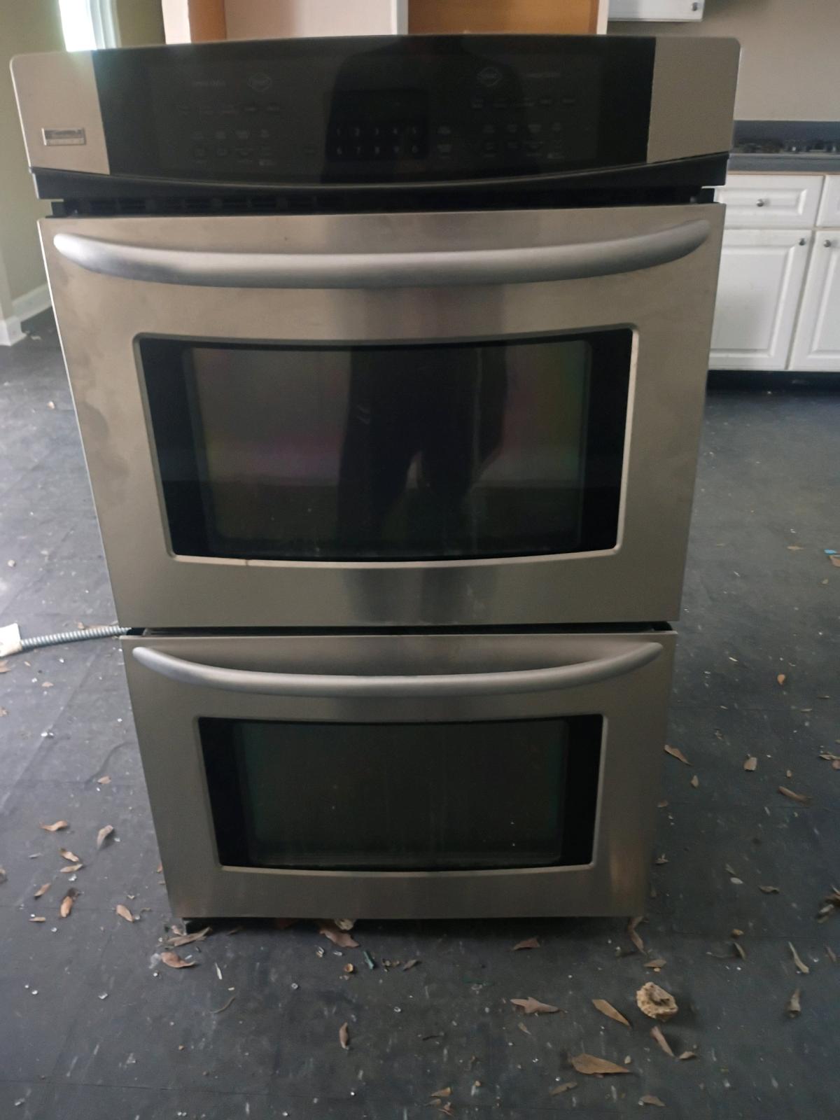 double oven with vent hood and countertop stove and dishwash