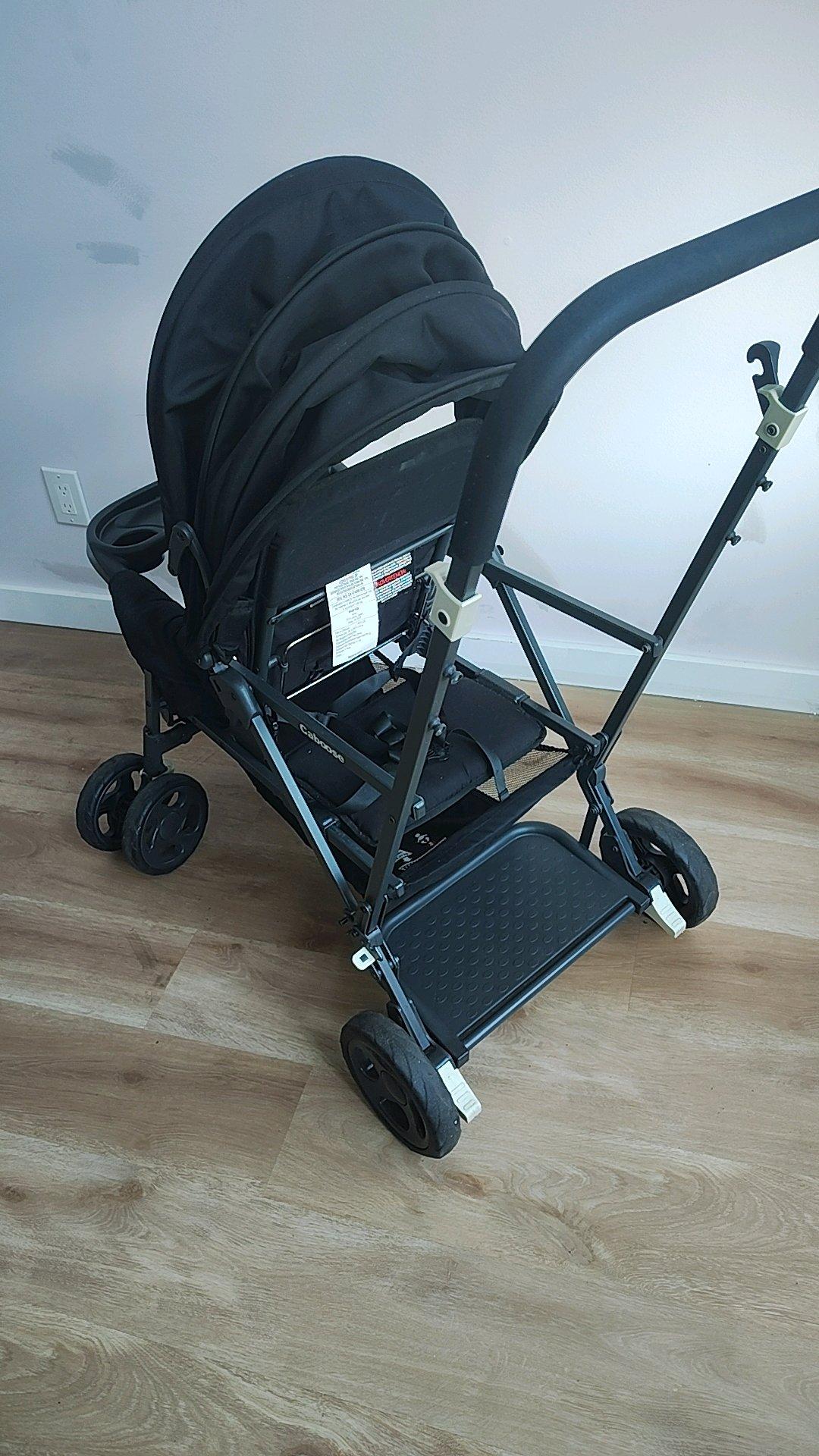 A Black Stroller built for 2 small children
