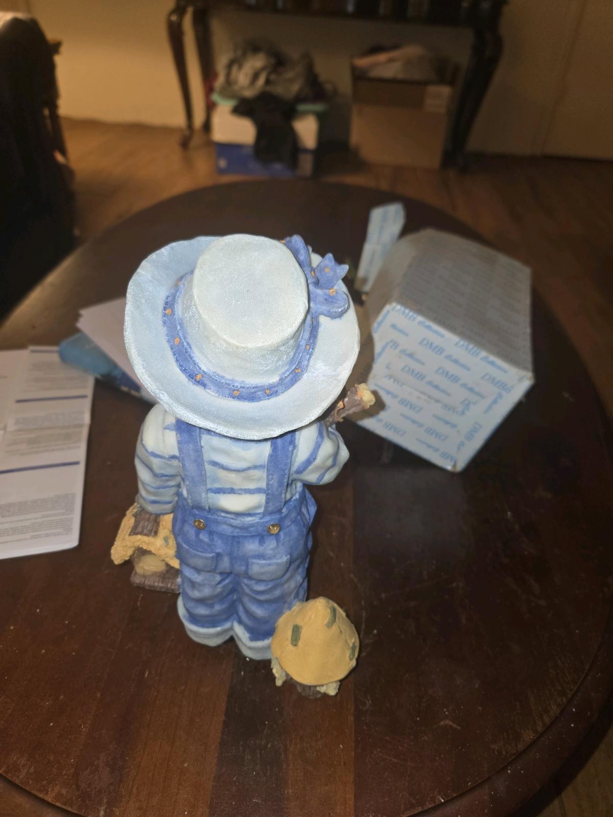 boyfigurine with blue overalls and hat and flowers