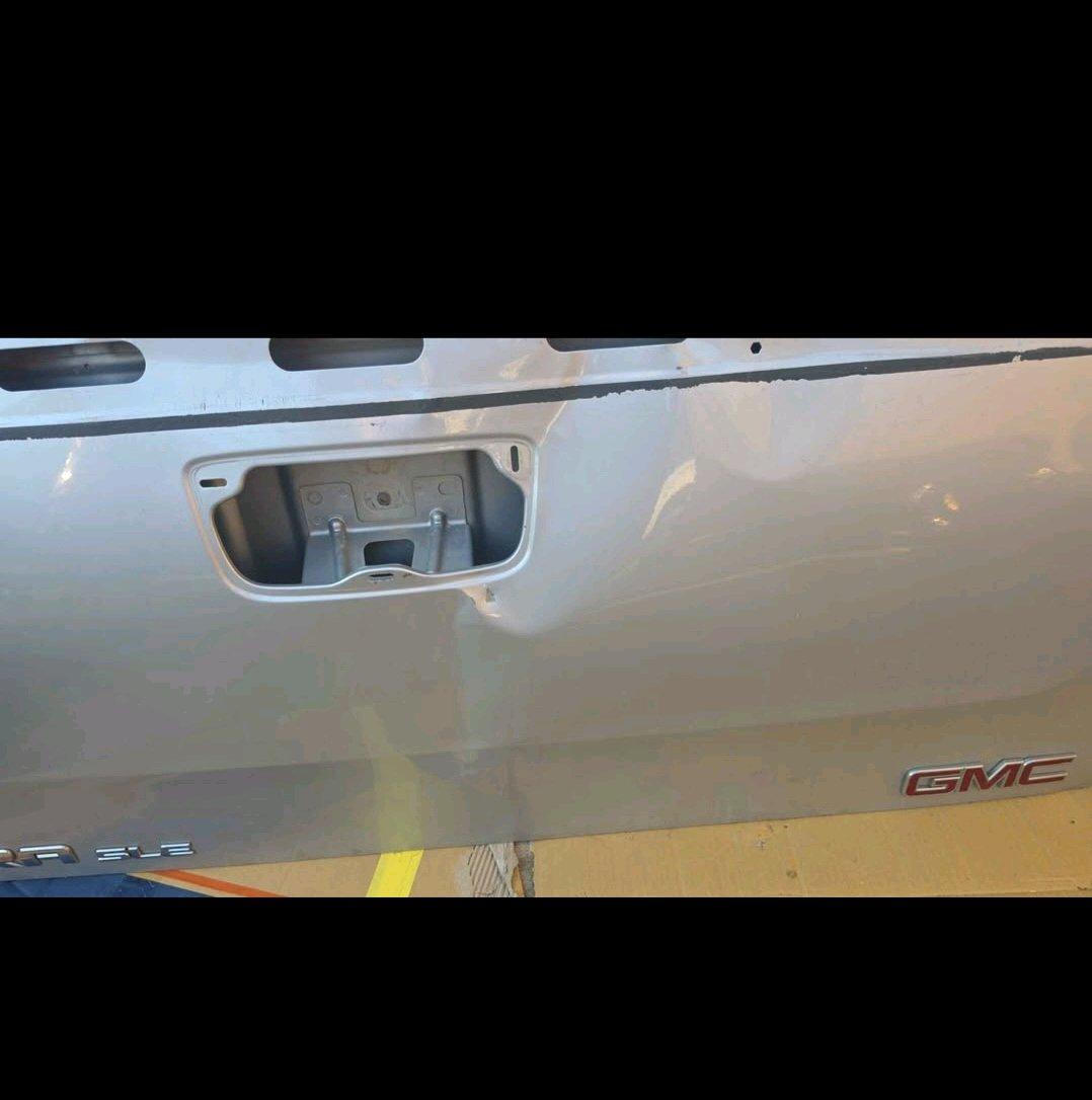 Silver GMC tailgate with minor dent
