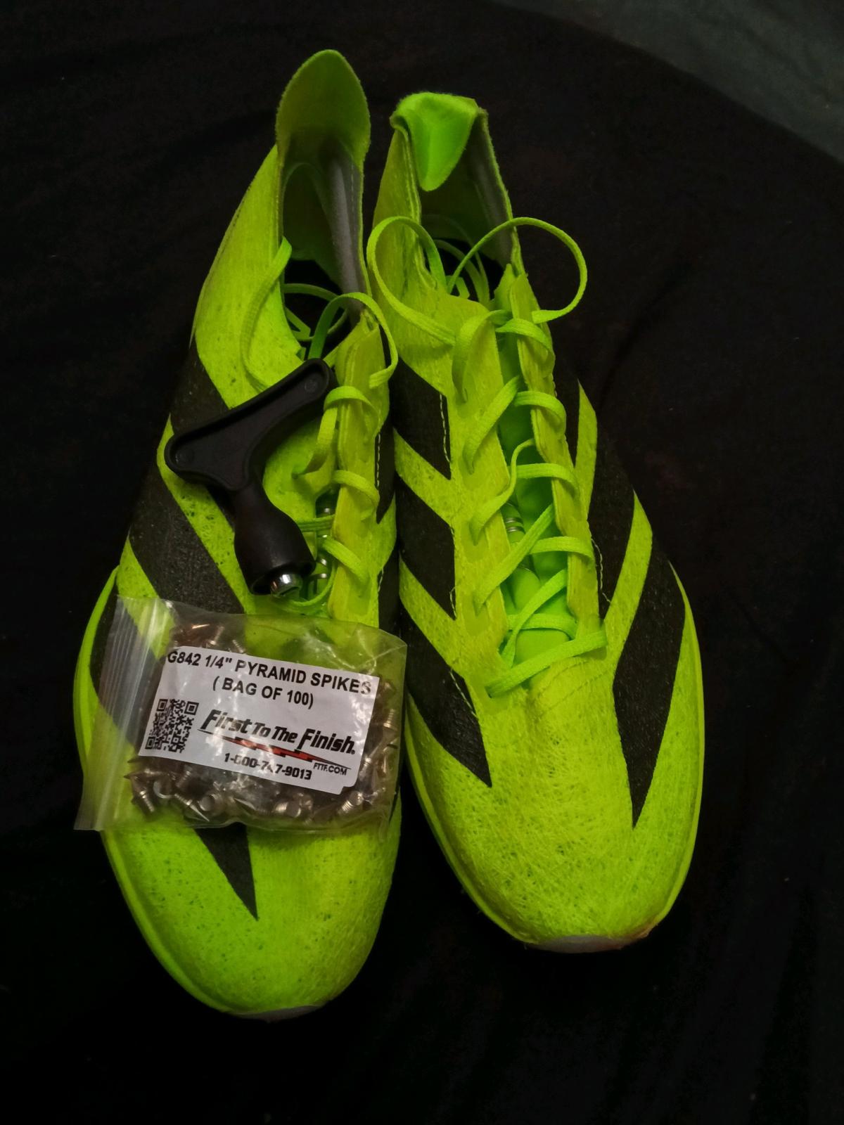 Adidas track shoes with spikes and spike tool