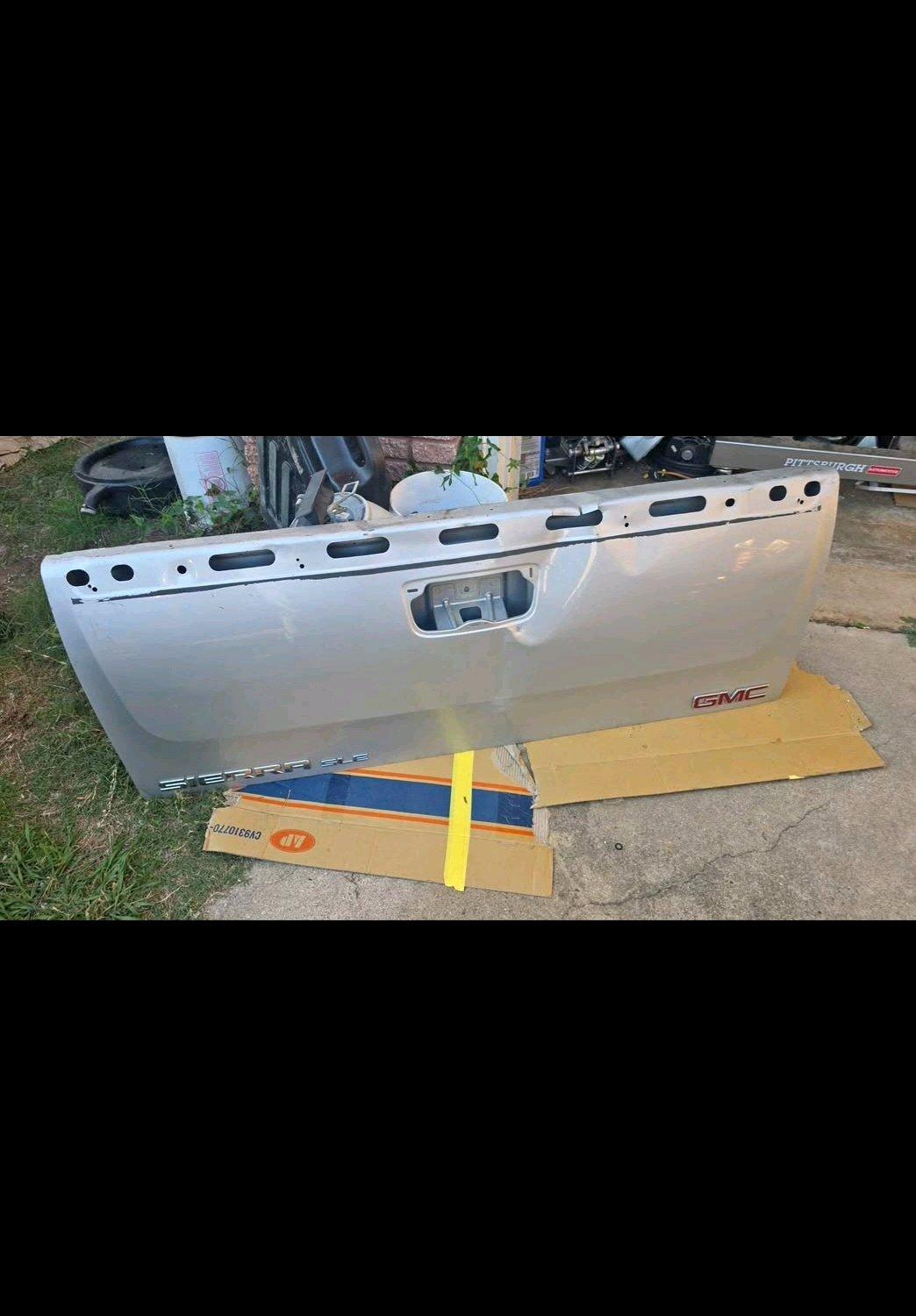 Silver GMC tailgate with minor dent