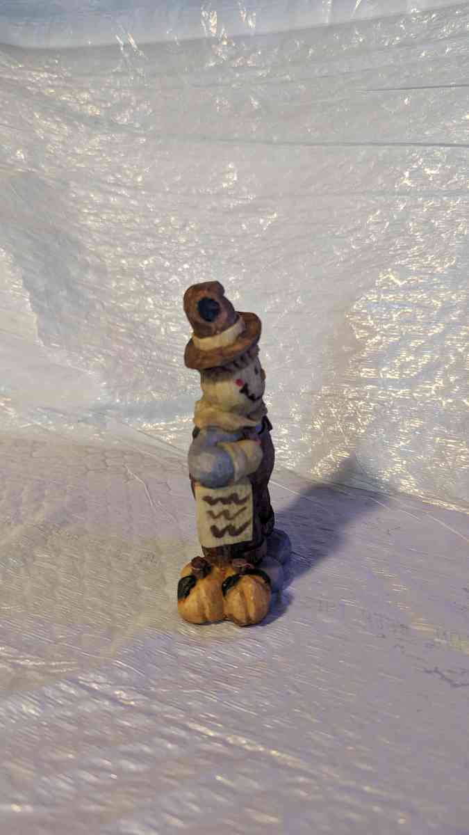 Happy Wood Scarecrow has a couple of Pumpkins and a little S