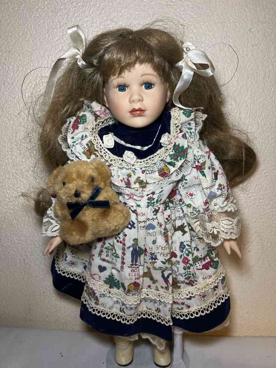 vintage porcelain doll hoding stuffed bear