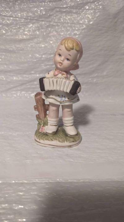 A Little Girl Playing an Accordion with a White Dress