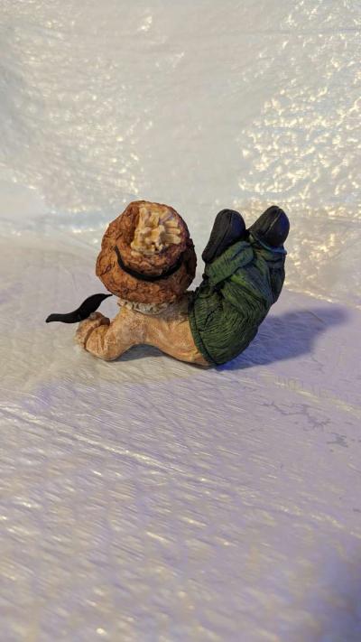 Resin Scarecrow Laying Down With Legs Bent Holding A Crow - Thumbnail 4