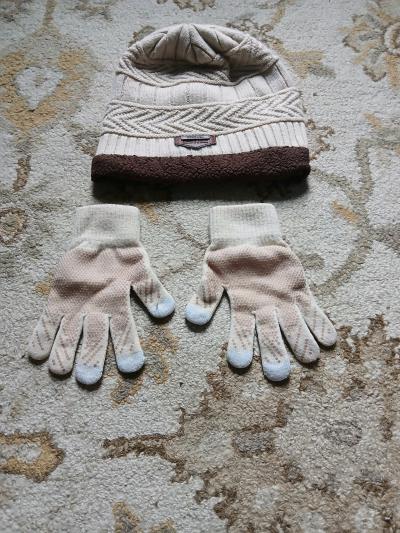 A cozy knit beanie hat and matching gloves The hat has a tex