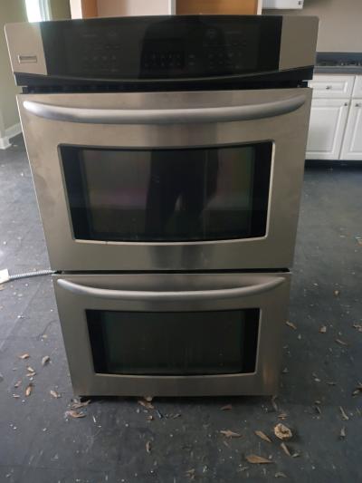 double oven with vent hood and countertop stove and dishwash
