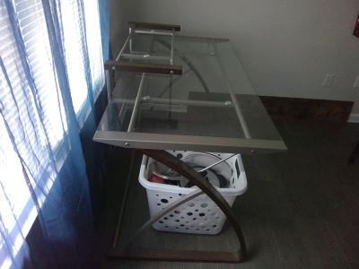A glass office desk  could be used for a computer desk for h
