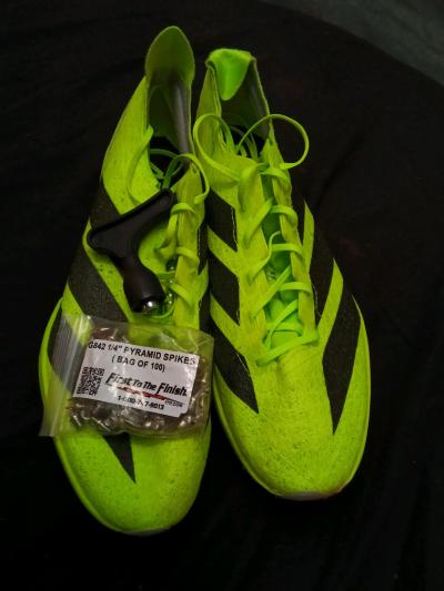 Adidas track shoes with spikes and spike tool