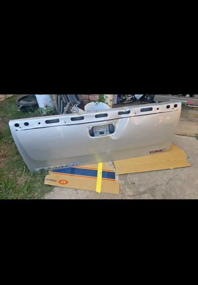 Silver GMC tailgate with minor dent